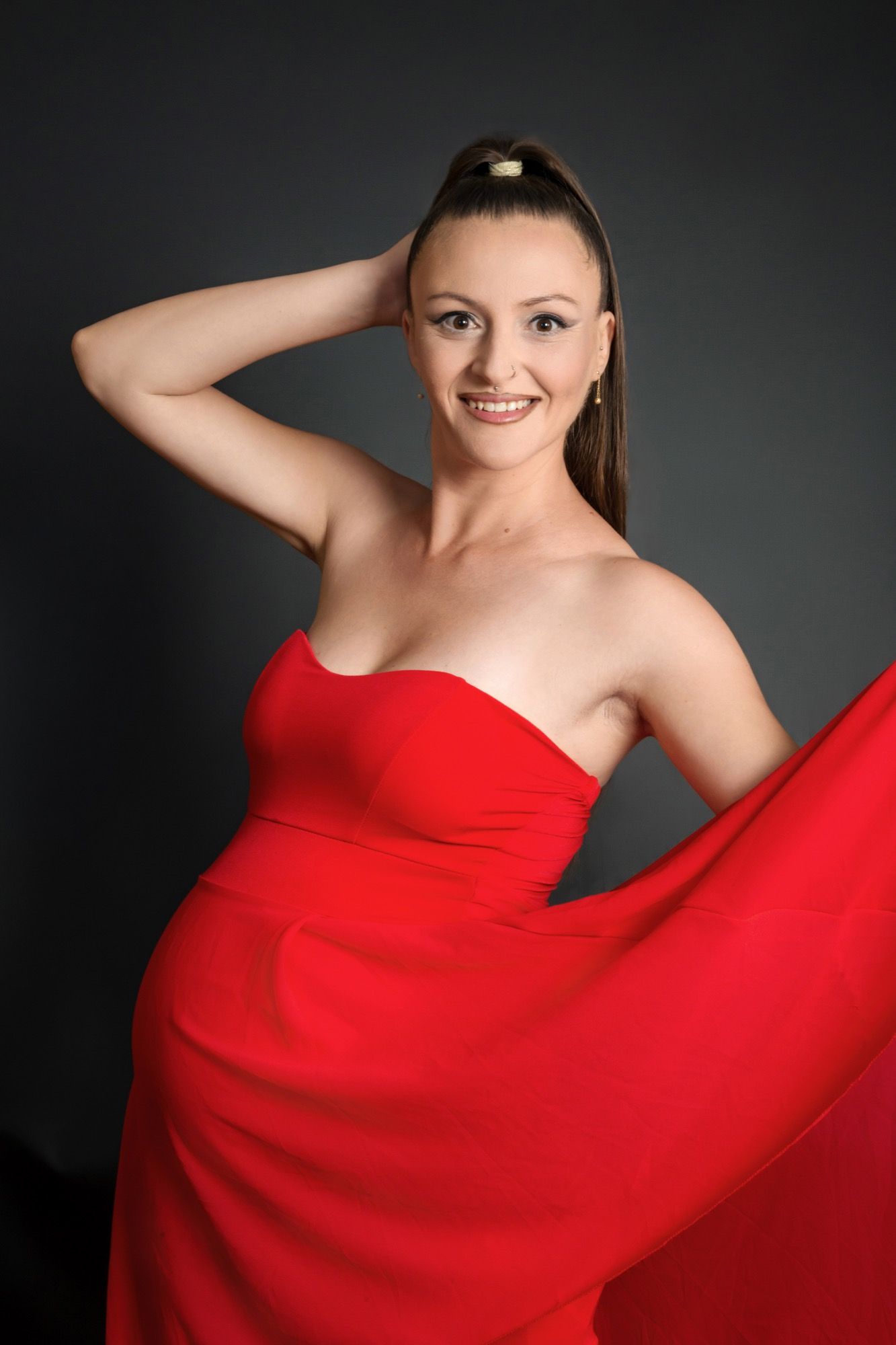 Schwangere im roten Kleid beim Babybauch-Shooting