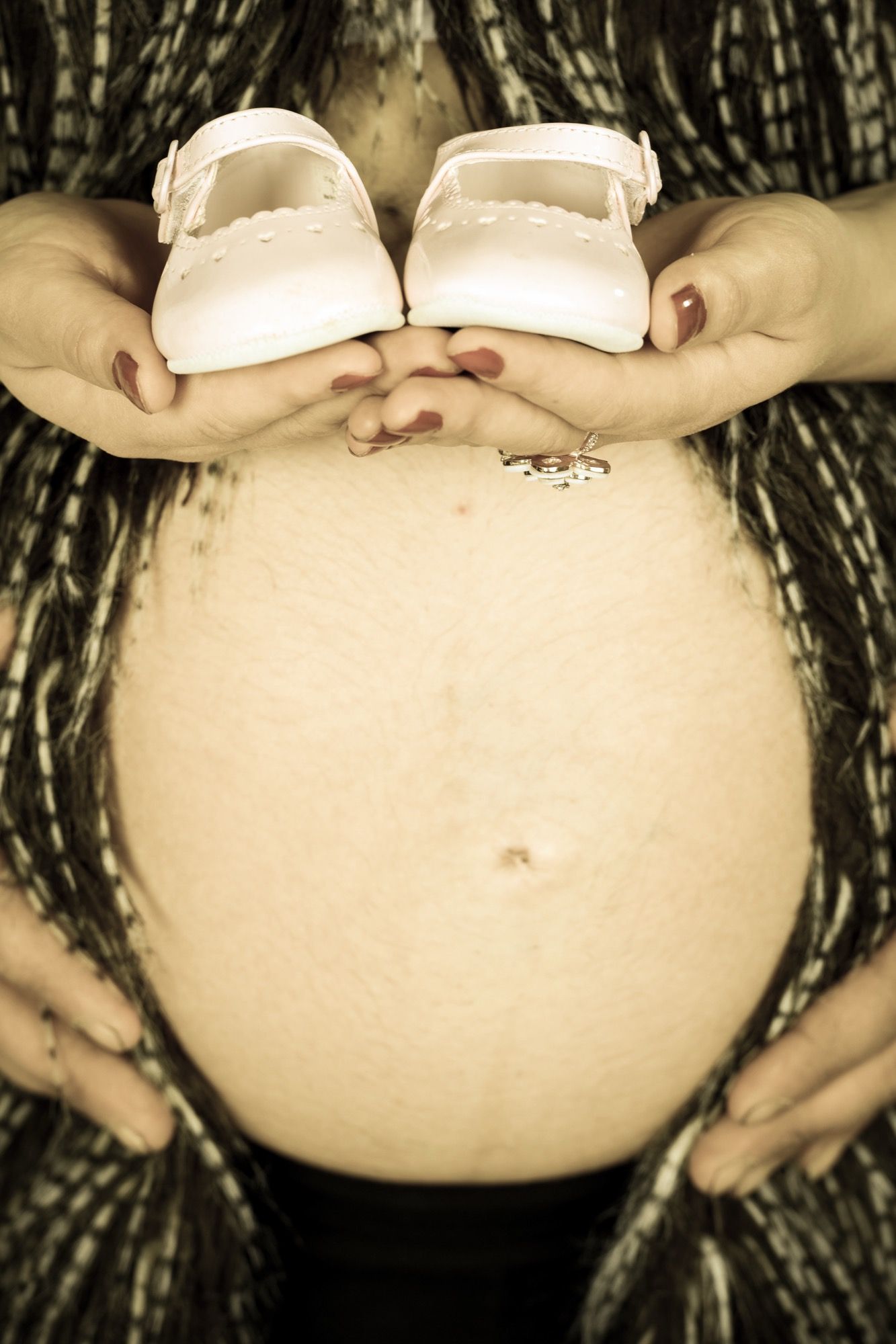 Babyschuhe auf dem Babybauch