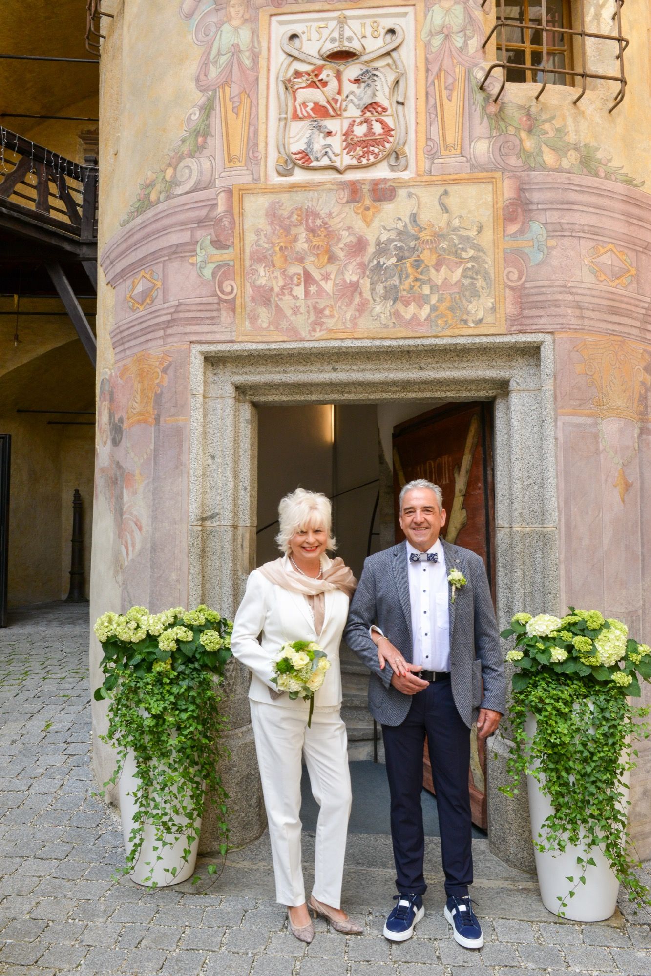 Brautpaar vor einem historischen Gebäude mit Fresken