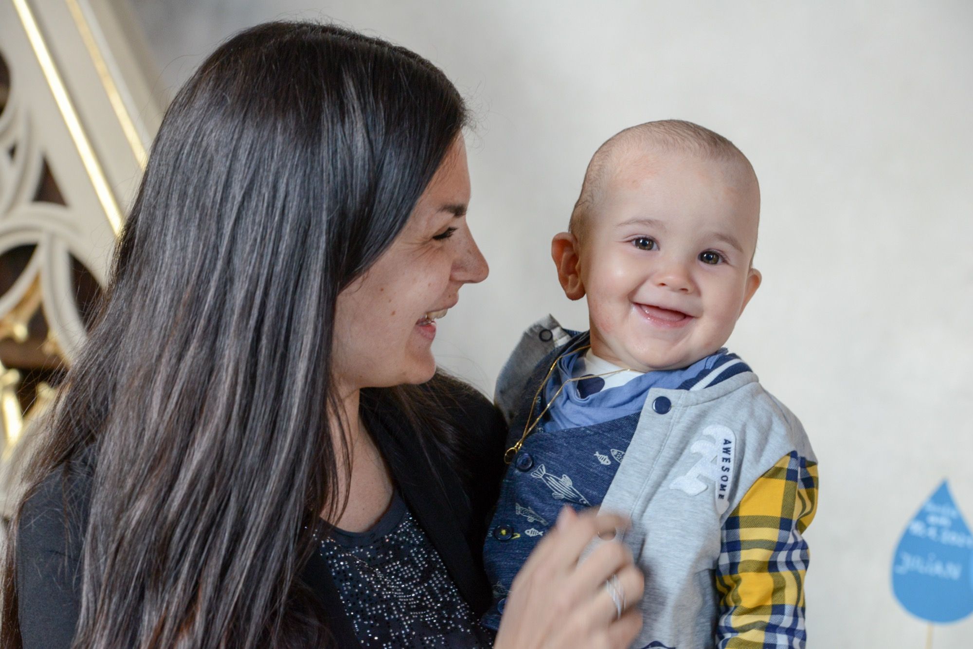 Mutter mit lachendem Kleinkind nach der Taufe
